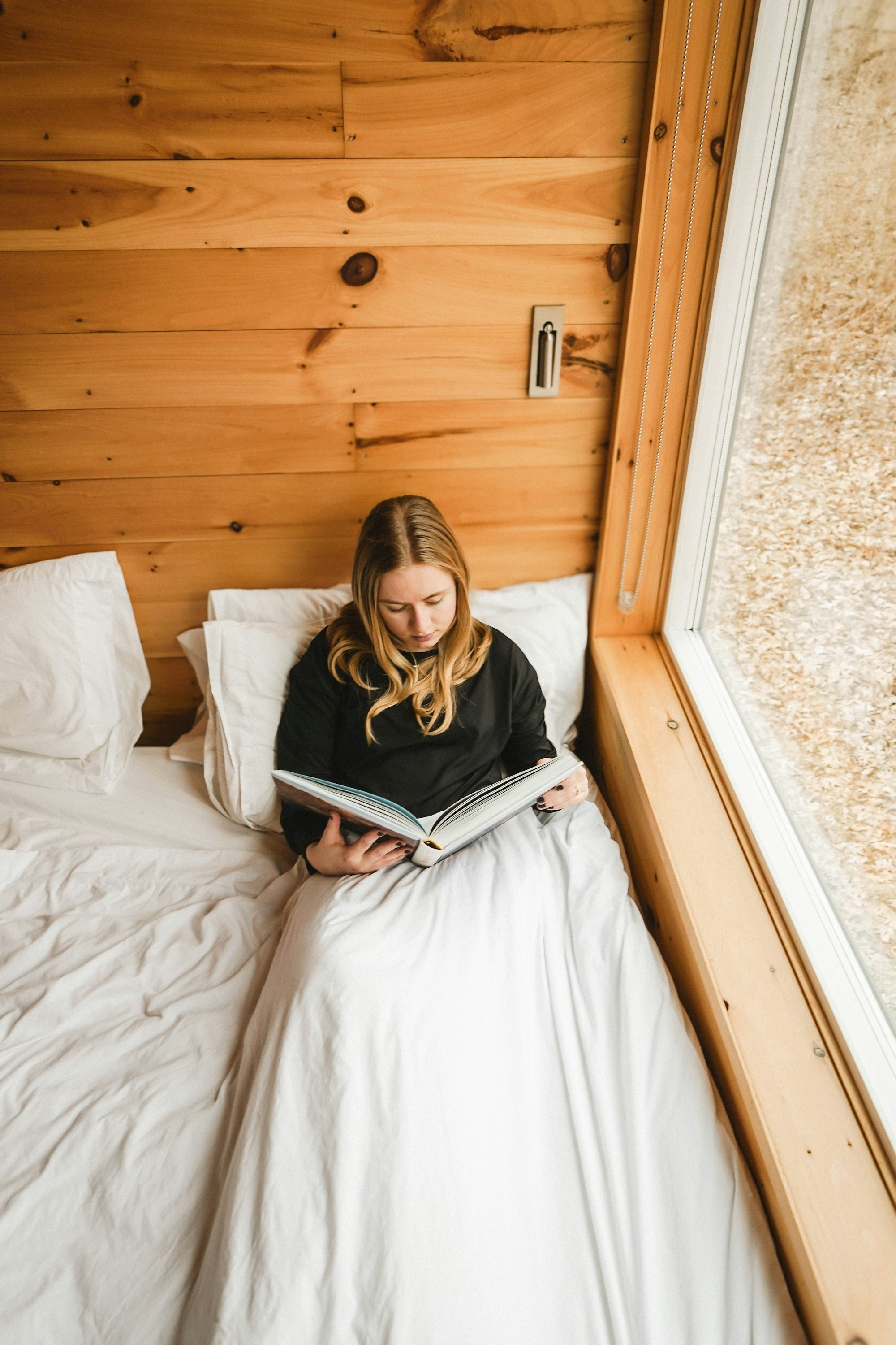 Reading a book in a cosy wooden cabin