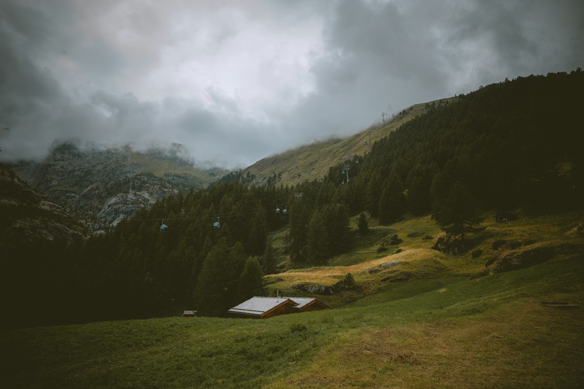 Small cabin on a mountainside in the clouds