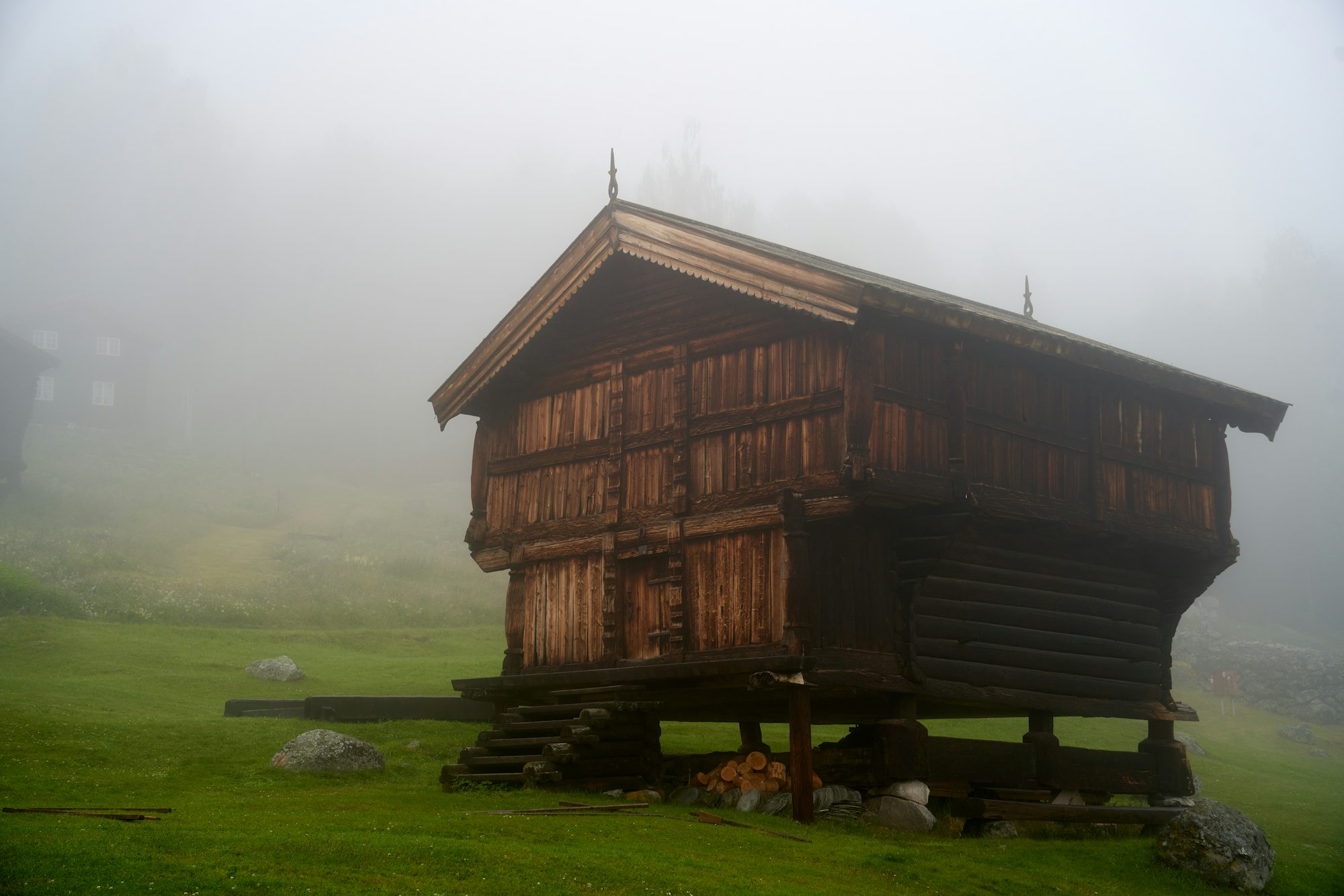 Wooden cabin on a foggy hillside