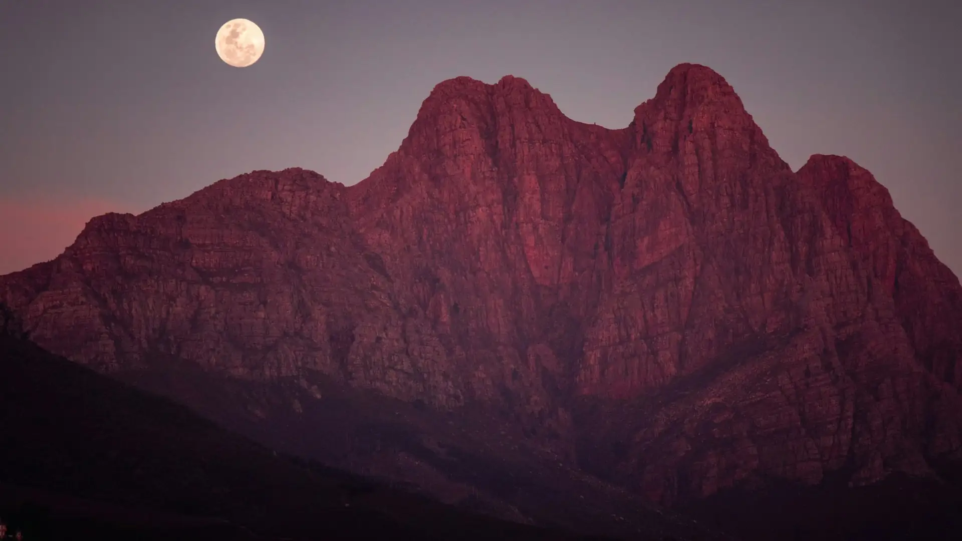 The moon rises over red rock